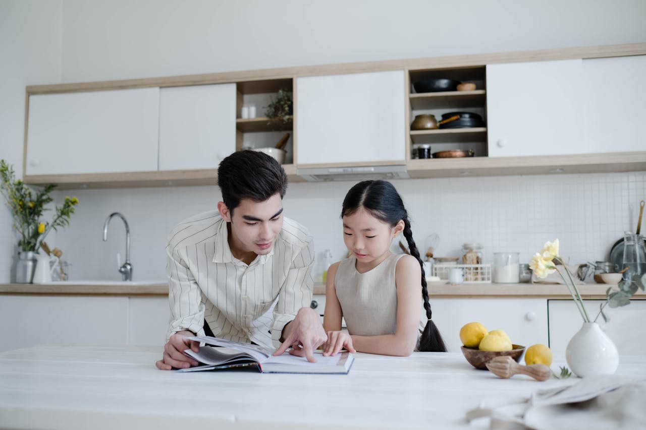 father and daughter reading cookbook